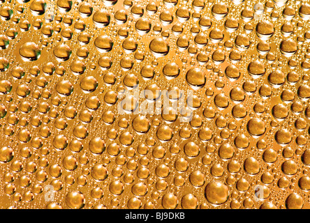 Rian gocce sul vetro, giallo oro colore di sfondo Foto Stock