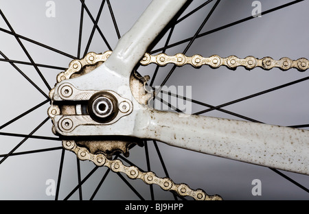 In prossimità della ruota posteriore, ruote dentate, raggi e catena di una singola velocità bicicletta da corsa Foto Stock