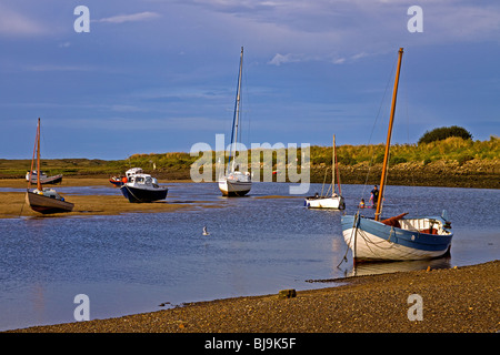 Barche a bassa marea nel porto naturale a Overy Staithe Norfolk Foto Stock