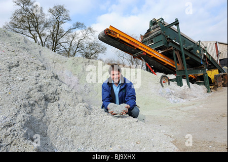 Herefordshire agricoltore Andrew Bayliss con la montagna di rifiuti shredded paper ready per ridurre in concime organico in worm pit a Enviroshred Foto Stock