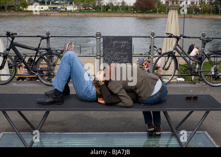 Coppia giovane appoggiato sul banco di moderno dal fiume con le biciclette Foto Stock