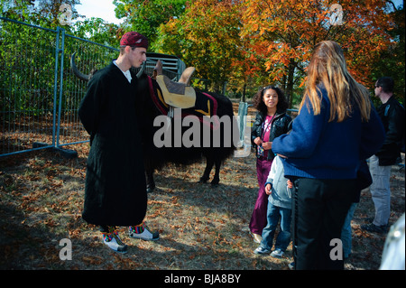 Parigi, Francia - famiglia giovane, maschio teen vestito in tibetano abiti tradizionali, nel parco, l'autunno. Foto Stock