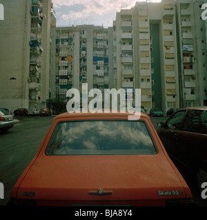 Arancione vecchia automobile parcheggiata di fronte appartment blocchi, Europa orientale Foto Stock