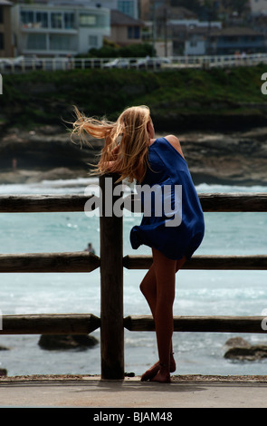 Una giovane donna bionda si appoggia contro una ringhiera a Bronte Beach, Sydney Foto Stock