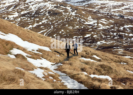 Due maschio walkers sul percorso fino Meall Nan Tarmachan con il Ben Lawers montagne sullo sfondo Foto Stock