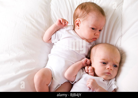 Un mese vecchio twin neonati affiancati sulla soffice coltre bianca Foto Stock