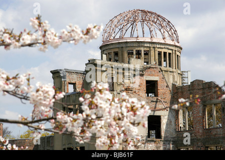 La cupola della bomba di Hiroshima, Giappone con la fioritura dei ciliegi in primo piano Foto Stock