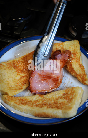 Un cuoco serve la pancetta con toast alla francese in un bed and breakfast la pensione prima colazione REGNO UNITO Foto Stock