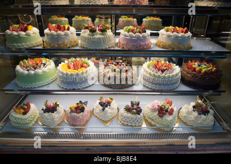 Torte colorate sul display nella finestra panettieri Foto Stock