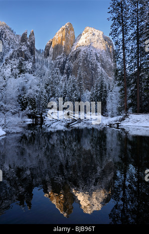 Cathedral Rocks e guglie riflesse nel fiume Merced dopo una nevicata in inverno il Parco Nazionale di Yosemite in California USA Foto Stock