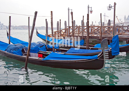 Gondole parcheggiato a loro posti barca sul Canal Grande della laguna veneta a Venezia Foto Stock