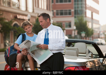 Imprenditore caucasico e figlio quotidiano di lettura Foto Stock