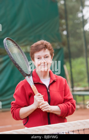 Senior donna ispanica giocando a tennis Foto Stock