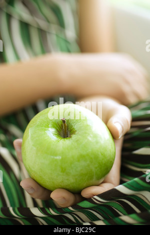 Donna che mantiene mela verde, tagliato Foto Stock