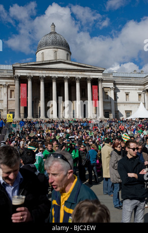 Una grande folla seduti sui gradini al di fuori della Galleria Nazionale durante la festa di San Patrizio a Londra Foto Stock