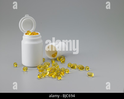 Capsule giallo fuoriuscita da un contenitore. Medio alto angolo. Foto Stock