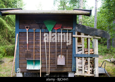 Utensili da giardinaggio appeso sul lato del capannone Foto Stock