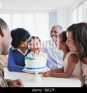 Famiglia americana africana guardando la nipote soffiare le candeline di compleanno Foto Stock