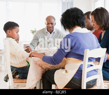 Famiglia americana africana pregare prima del pasto Foto Stock