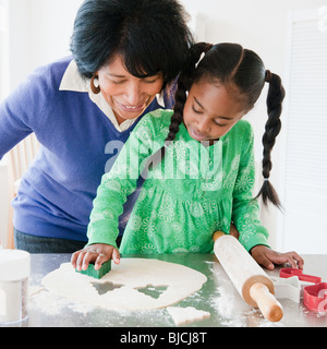 Nonna nero i biscotti di cottura con il nipote Foto Stock