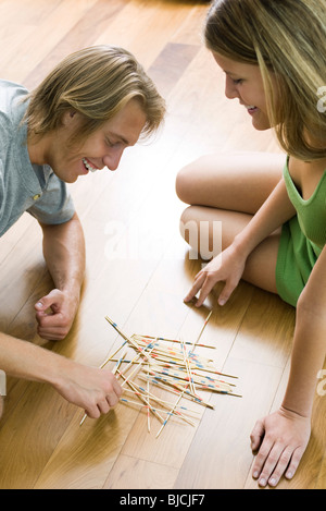 Giovane giocando pick up sticks insieme Foto Stock