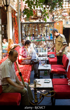 Uomo di fumare narghilè o tubo di acqua, in Istanbul tea house, Turchia Foto Stock
