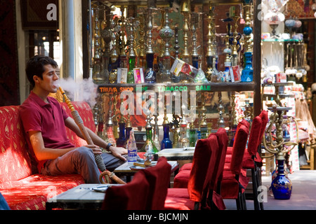 Uomo di fumare narghilè o tubo di acqua, in Istanbul tea house, Turchia Foto Stock
