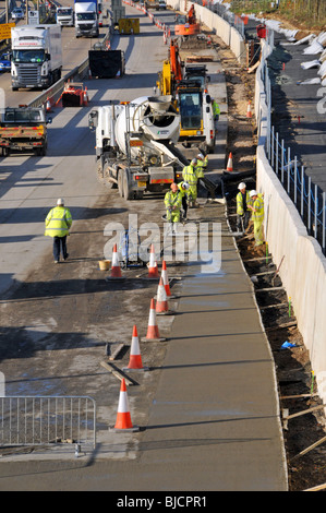 Ingegneria civile lavori stradali lavoratori edili e macchine che lavorano in cantiere M25 costruzione di un'autostrada a quattro corsie totale Essex paesaggio Inghilterra Regno Unito Foto Stock