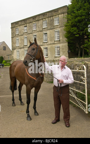 Milton Bradley delle corse ippiche trainer con uno dei suoi cavalli da corsa brevità a Mead's Farm Sedbury parco vicino a Chepstow Foto Stock