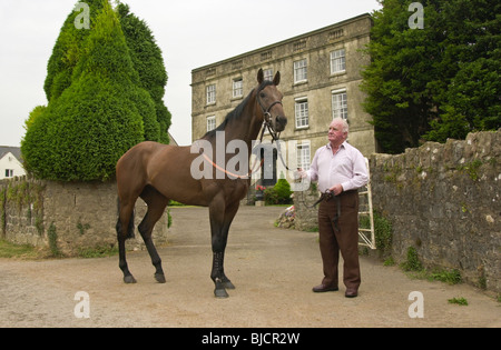 Milton Bradley delle corse ippiche trainer con uno dei suoi cavalli da corsa brevità a Mead's Farm Sedbury parco vicino a Chepstow Foto Stock