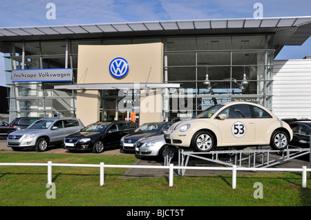 Insegna aziendale e logo del concessionario Inchcape Volkswagen sull'ingresso dello showroom e sull'esposizione all'aperto delle vetture VW nell'East London Inghilterra Regno Unito Foto Stock