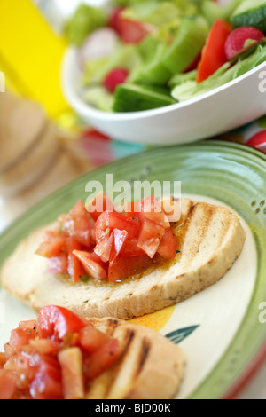 Tritate in italiano o in stile mediterraneo pomodori maturi su tostato Bruschetta con olio di oliva con n. di persone Foto Stock