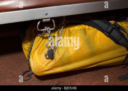 India Kerala, Kochi, viaggi ferroviari sicurezza, viaggiatori occidentali sacchetto fissato con catena e lucchetto sotto la sede ferroviaria Foto Stock