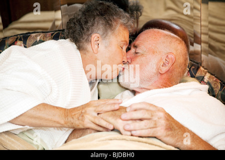 Romantico coppia senior a letto kissing buonanotte. Foto Stock