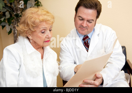 Senior donna impara dal suo medico che la sua assicurazione non coprire il trattamento. Foto Stock