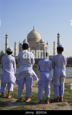 Giovani Musulmani ragazzi eseguono religiosi la preghiera Namaz nella parte anteriore del Taj Mahal sulla banca del fiume Yamuna ; Agra ; Uttar Pradesh ; India Foto Stock