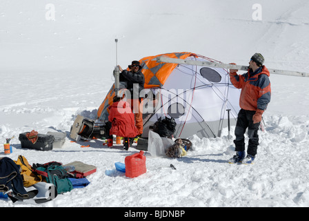 Persone sul ghiaccio del lago con attrezzature scientifiche/tecniche, Lac Blanc, Chamonix, Francia Foto Stock