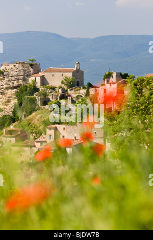Saignon, Luberon, Provenza, Francia. Papaveri & vista del villaggio Foto Stock