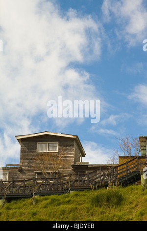 Case in legno sulla collina con cieli drammatici Foto Stock