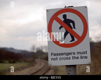 Avviso "passeggeri non devono attraversare la linea' su una piccola stazione ferroviaria rurale nel North Yorkshire Foto Stock