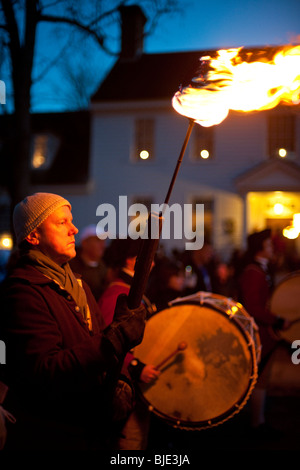 Un uomo che porta una torcia fiammeggiante durante la parata natalizia a Colonial Williamsburg, Virginia, Stati Uniti d'America Foto Stock