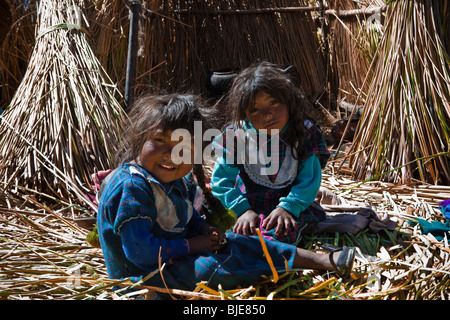 Su isole galleggianti Uros, bambini che giocano in canneti , Puno, Altiplano, il lago Titicaca, Desaguadero fiume, Perù, Sud America Foto Stock