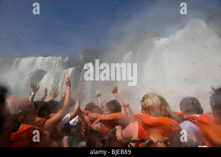 Gruppo di turisti getting imbevuto sul motoscafo sotto la caduta mbigua cascate Iguazu National Park Repubblica argentina Foto Stock