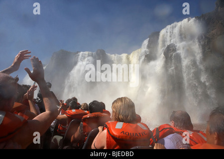 Gruppo di turisti getting imbevuto sul motoscafo sotto la caduta mbigua cascate Iguazu National Park Repubblica argentina Foto Stock