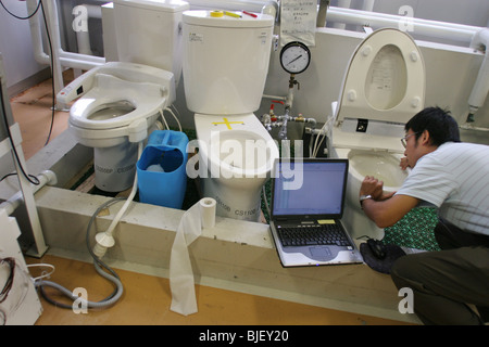 Un dipendente controlla le funzioni di acqua di vari tipi di bagni, nei laboratori di ricerca della Toto. Kokura, Giappone. 08.08.0 Foto Stock