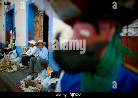 Un ballerino Chinelo poggia sul margine delle feste di carnevale i fornitori che vendono souvenir per turisti in Tlayacapan, Messico Foto Stock