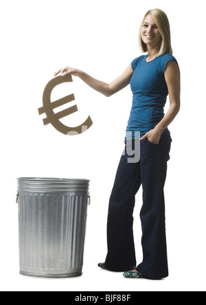 Donna gettando simbolo euro nel cestino Foto Stock