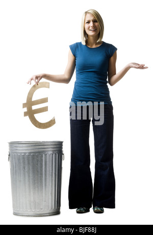 Donna gettando simbolo euro nel cestino Foto Stock