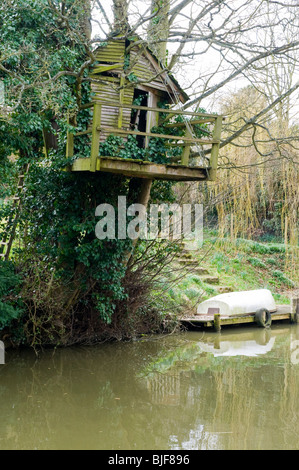 Un muschio coperto tree house sulla banca del Oxford Canal vicino Heyford inferiore, Oxfordshire Foto Stock