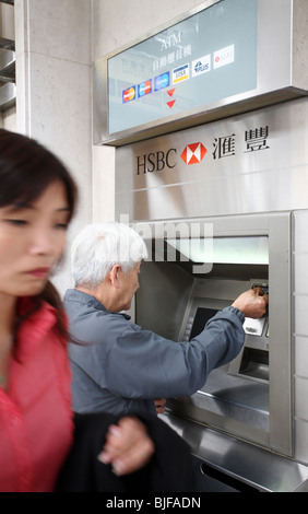 Un uomo in corrispondenza di una sede HSBC bancomat, Macao, Cina Foto Stock